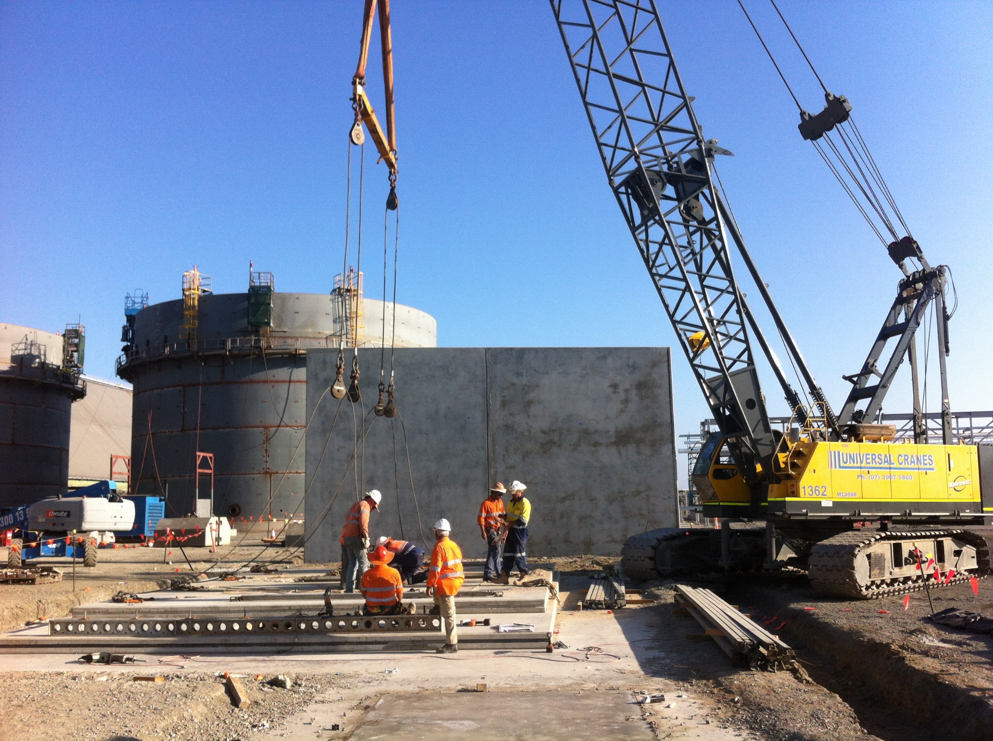 Crane and construction crew preparing a concrete panel lift
